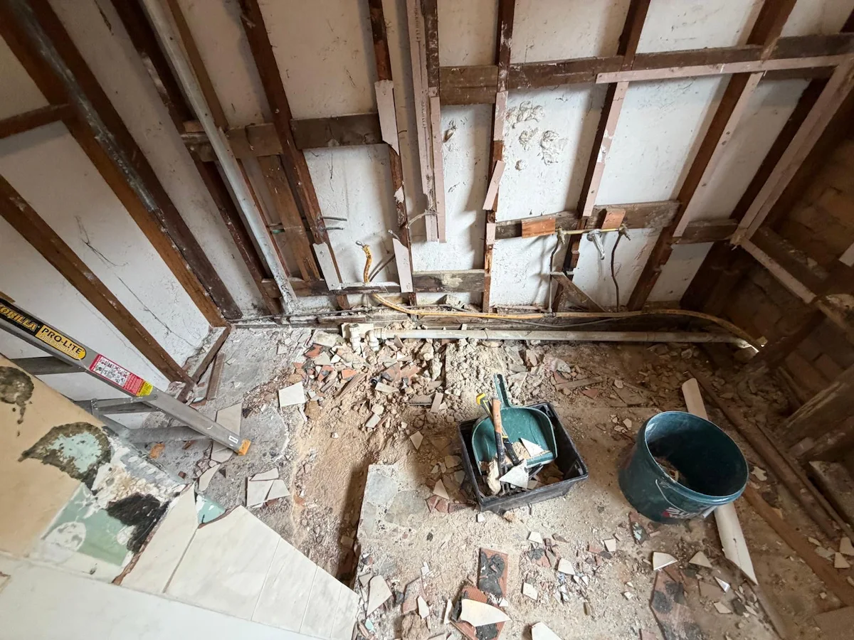 Bathroom strip-out showing the floor and existing construction during demolition