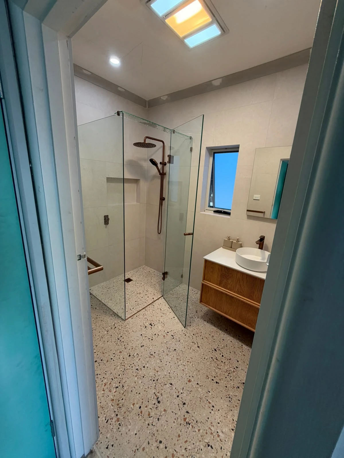 Completed Fawkner bathroom renovation with frameless shower, terrazzo-look flooring and timber-look vanity