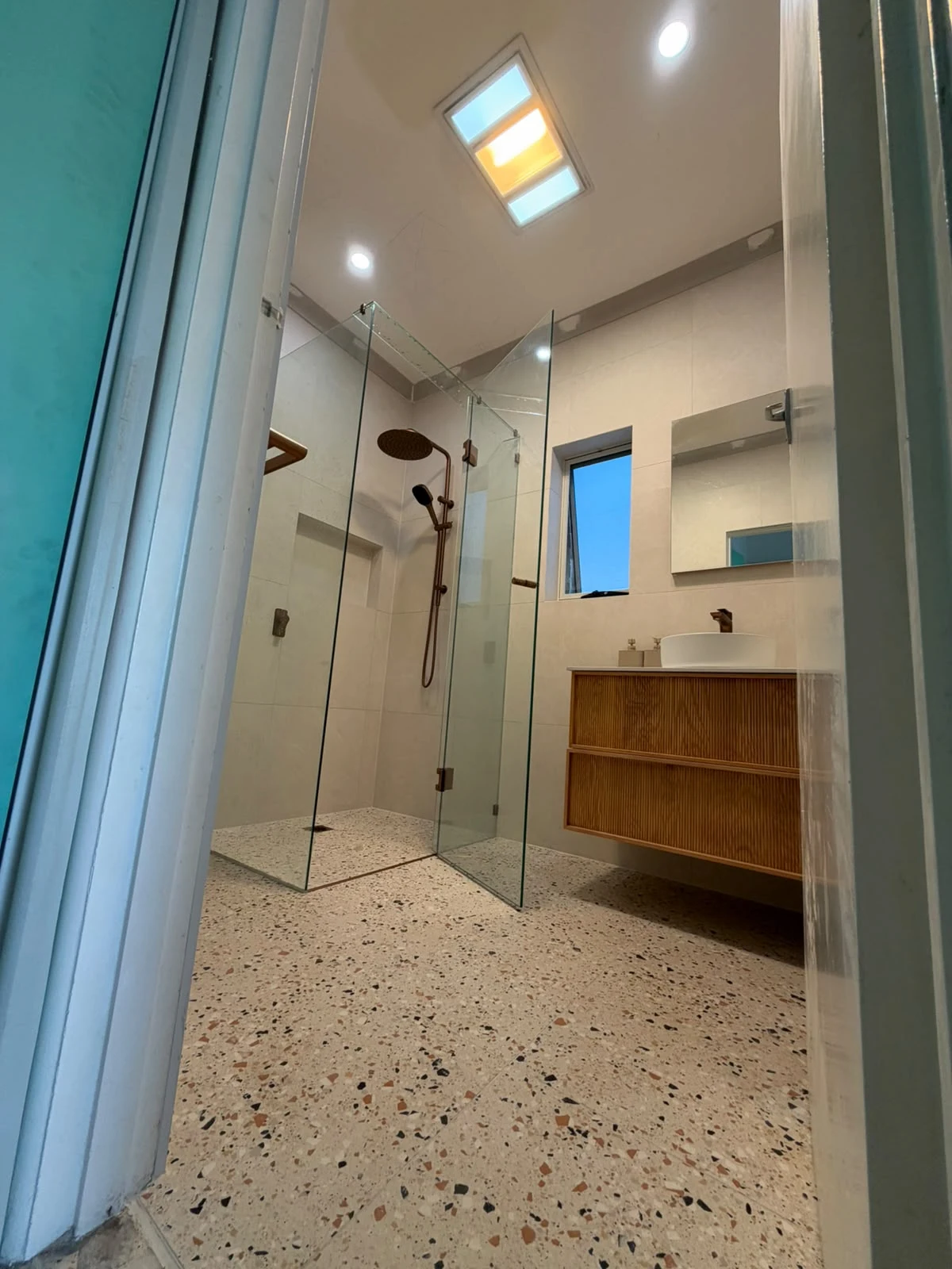 Frameless glass shower and timber-look vanity in the completed Fawkner bathroom