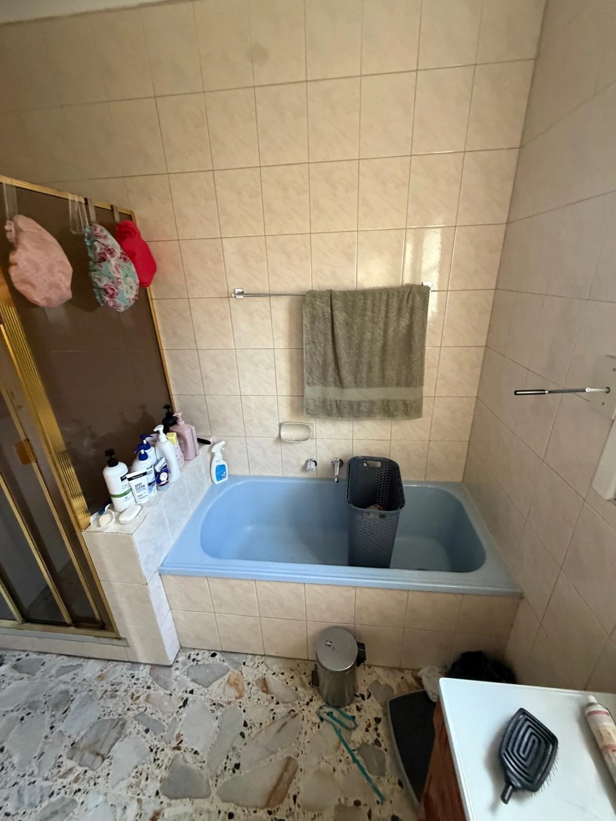 Original blue bathtub and gold-framed shower in the Fawkner bathroom before renovation
